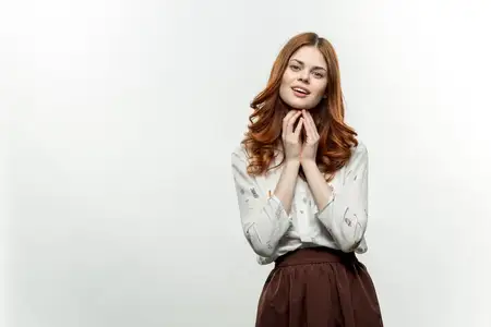 Эмоциональная элегантная женщина жестикулирует руками, на ней деловой костюм, студийная съёмка на изолированном фоне