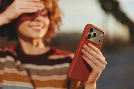 Женщина на открытом воздухе в стиле лайфстайл делает селфи на смартфон, улыбаясь
