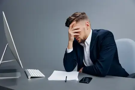 Красивый бизнесмен с телефоном, полный эмоций, работает перед компьютером