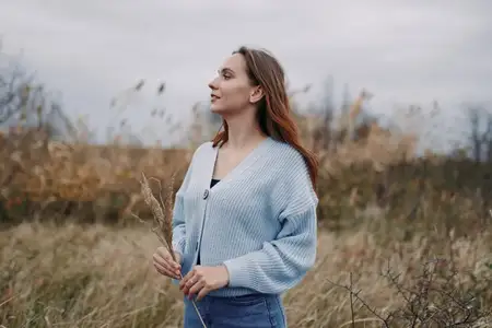 Контекстная сцена образа жизни, показывающая тихое созерцание в сельском поле с пасмурным небом, тонкими земляными тонами и честным выражением, подчеркивающая подлинную простоту, надежность и…