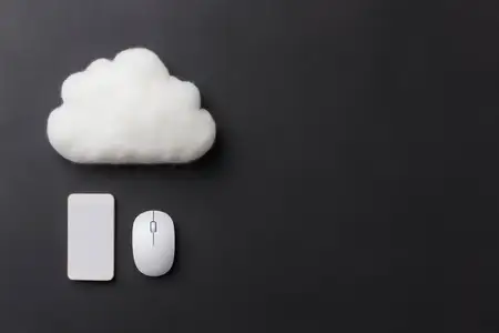 Креативная плоская композиция, включающая смартфон, компьютерную мышь и мягкое облако, представляющая концепцию цифрового хранения и интеграции технологий в минималистичном рабочем пространстве