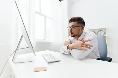 Красивый бизнесмен работает за компьютером, излучая уверенность в себе и профессионализм в офисе