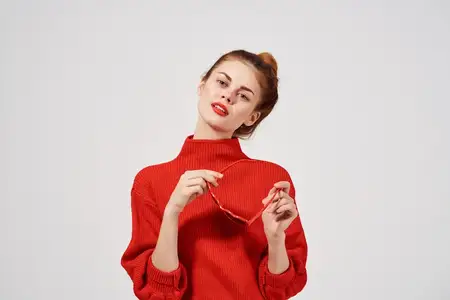 Красивая женщина с красными губами позирует на светлом фоне