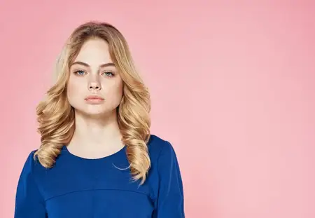 Элегантная женщина в синем платье, кадрированный вид, розовый фон, модель