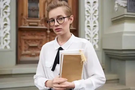 Студент на улице возле здания отдыхает, ведёт размеренный образ жизни