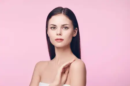 Красивая молодая женщина с чистой кожей на розовом фоне, с местом для вашего сообщения