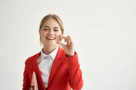 Женщина держит в руках биткоин, криптовалюту, на изолированном фоне