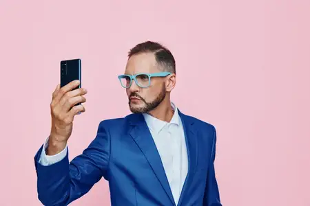 Изолированный цветной фон подчеркивает корпоративное настроение, демонстрируя делового профессионала со спокойными эмоциями, амбициями и вовлеченностью через автопортрет