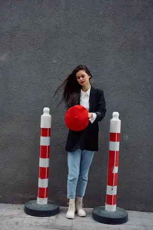 Модная женщина стоит на улице на фоне города и дорожных работ