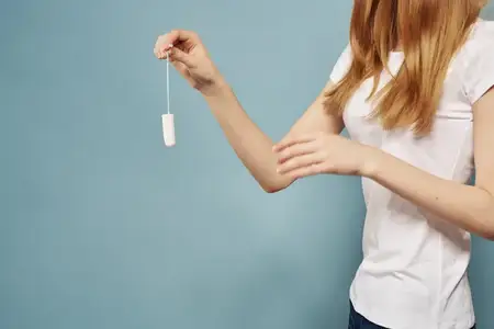 Женщина в джинсах и футболке, менструация