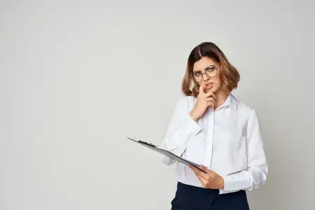 Женщина в белой рубашке работает с официальными документами, демонстрируя профессиональный подход
