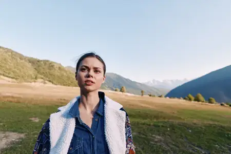 Портрет женщины на природе с горами и лугом