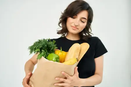 Женщина в черной футболке с пакетом продуктов, здоровая пища, домашняя работа
