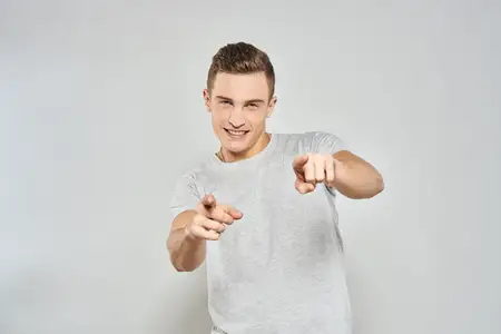 Крупный план симпатичного мужчины в светлой футболке, снятый в студии на изолированном фоне