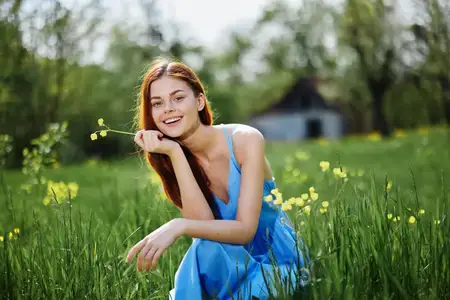 Весной женщина на природе улыбается, обнажая зубы