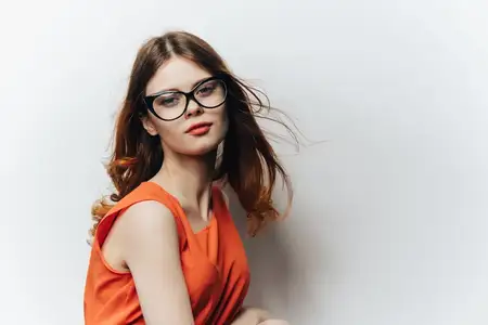 Женщина в оранжевом сарафане с блокнотом в руке на светлом фоне