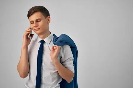 Мужчина в рубашке с галстуком разговаривает по телефону в профессиональном рабочем офисе