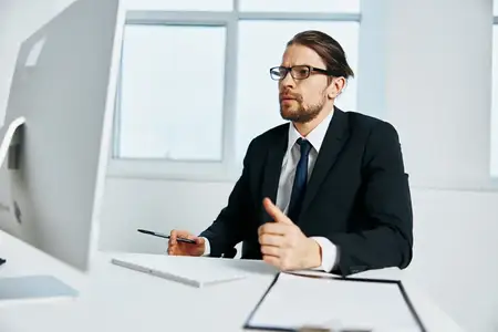 Мужчина в костюме, официальное лицо, работает за компьютером