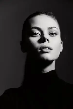 Уравновешенная молодая женщина смотрит прямо в камеру, излучая уверенность и элегантность