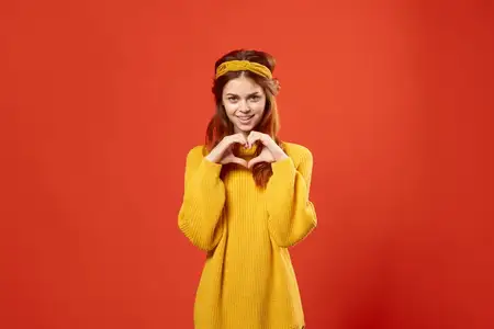 Красивая женщина с повязкой на голове, аксессуарами в стиле хиппи и украшениями на красном фоне