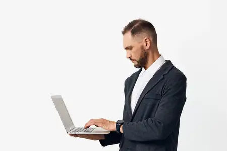 Портрет запечатлевает корпоративного профессионала, проявляющего решительность и спокойную энергию, пока он работает на лёгком ноутбуке