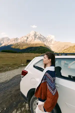 Женщина и машина возле гор