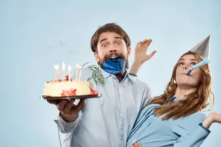 Эмоциональный мужчина с тортом и красивая женщина на дискотеке на синем фоне