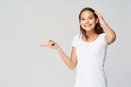 Веселая женщина в белой футболке указывает в сторону