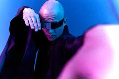 Поразительный портрет мужчины в футуристических очках, излучающего уверенность смелой позой