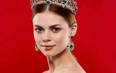 Портрет красивой женщины с диадемой на голове на красном фоне