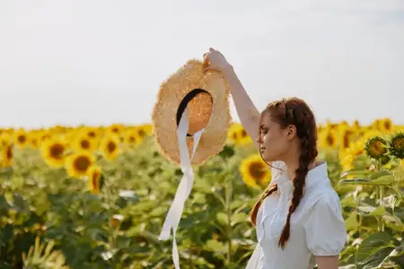 Портрет женщины, смотрящей в поле подсолнухов