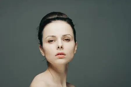 Симпатичная брюнетка, эмоции, обнажённое плечо, рука на лице, роскошь