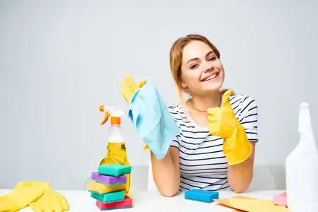 Уборщица проводит уборку квартиры на светлом фоне