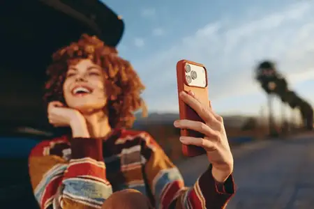 Женщина ведет активный образ жизни, делает селфи на смартфон на улице на тихой улице