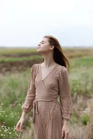 Портрет красивой женщины с длинными волосами в платье, излучающей шарм на открытом воздухе