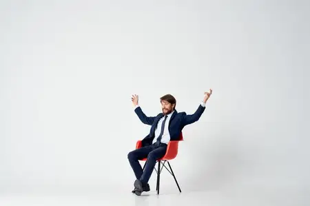 Деловой мужчина в костюме сидит на стуле в офисе, работа менеджера