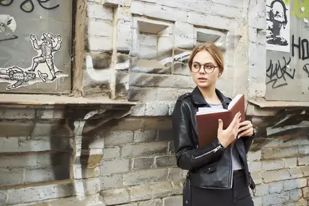 Привлекательная женщина в кожаной куртке позирует в студии и прогуливается на улице