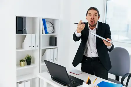Мужчина работает в офисе с документами, на его лице читаются эмоции