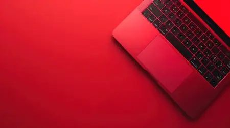 Вид сверху на гладкий красный ноутбук на соответствующем фоне, идеально подходит для концепций современных технологий и цифрового образа жизни