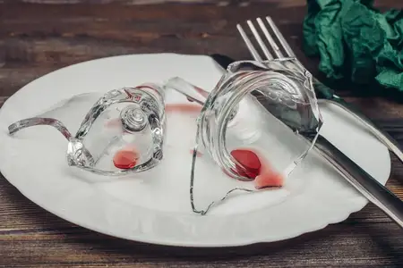 Разбитое стекло на тарелках, сервировка кухонной посуды, накрытый стол, столовые приборы