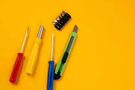Отвёртки и строительные инструменты на жёлтом фоне, оборудование для ремонта, промышленность