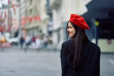 Женщина улыбается, гуляет по городу на фоне офисных зданий, в стильной модной винтажной одежде и с макияжем, весенняя прогулка, путешествие