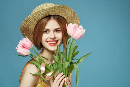 Весёлая женщина в шляпе с букетом цветов, элегантность, роскошь, студийная съёмка, обрезанный вид