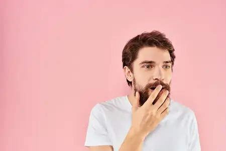 Мужчина в белой футболке жестикулирует руками, передавая эмоции