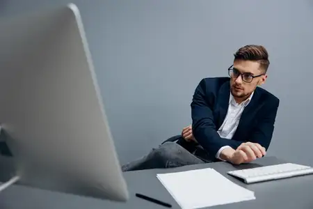 Красивый бизнесмен в очках работает за компьютером на изолированном фоне