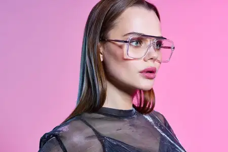 На фотографии в высоком качестве изображена красивая женщина с ярким макияжем в модной одежде на дискотечном розовом фоне, что создаёт ощущение роскоши