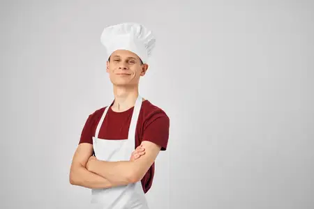 Повар-мужчина в белом фартуке на кухне, профессионал