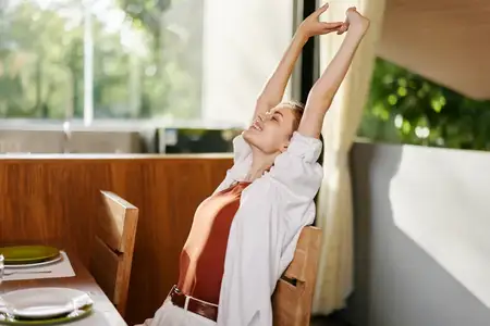 Молодая привлекательная женщина европейской внешности в белой одежде сидит на кровати в своей спальне