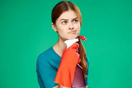 Эмоциональная уборщица с моющим средством в резиновых перчатках за работой