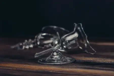 Битая стеклянная посуда на деревянном столе, крупный план, повреждения